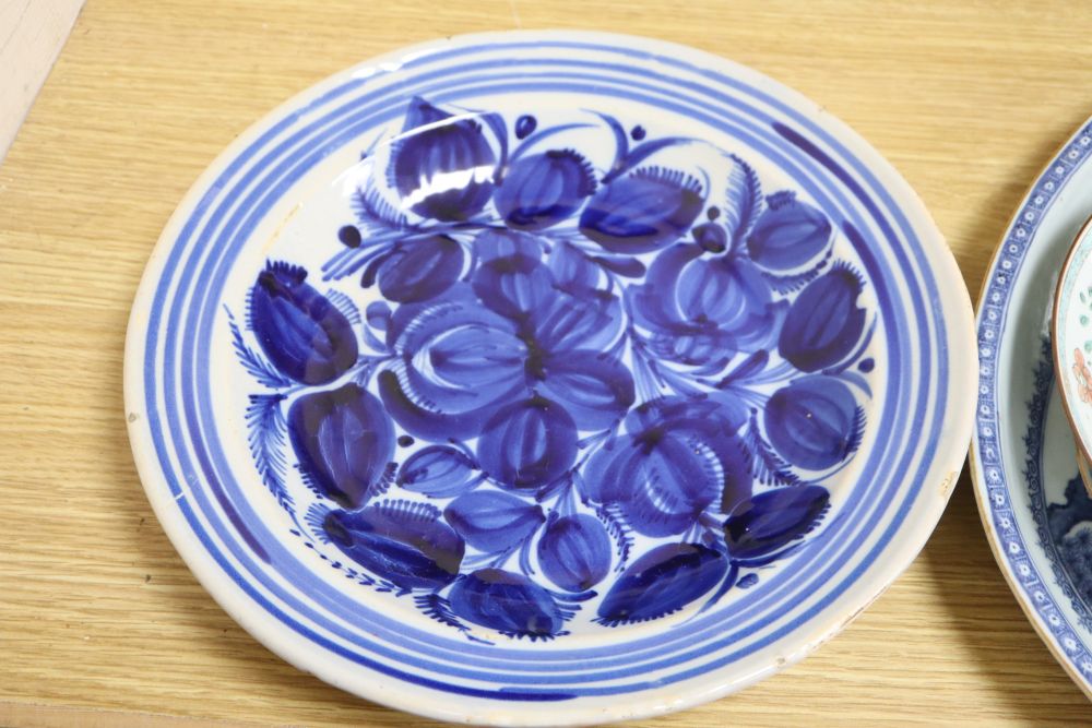 An early 19th century Chinese floral plate, a Chinese blue and white plate and meat platter, together with two other dishes